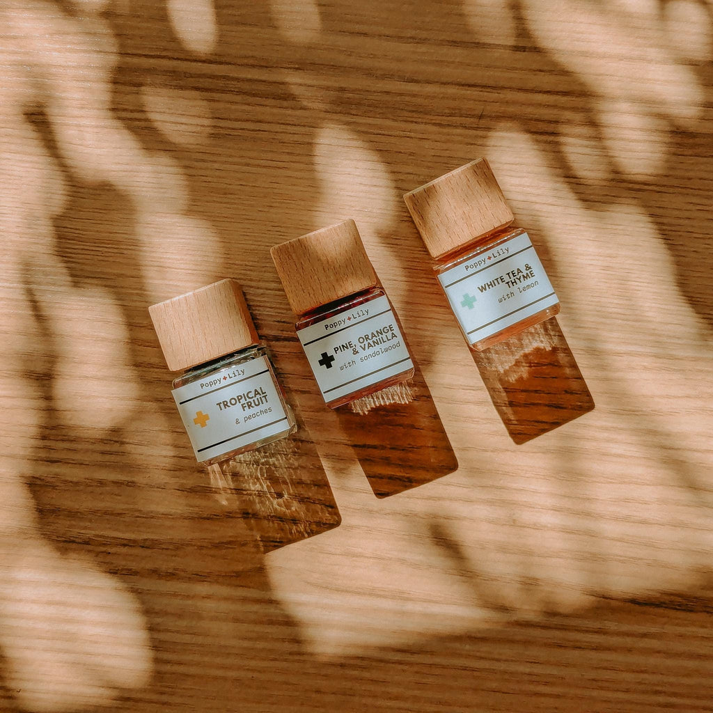 Three small bottles of diffusers with wooden caps on a wooden surface