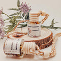 Cherry Blossoms Gardenia diffuser on a wooden block with flowers in the background